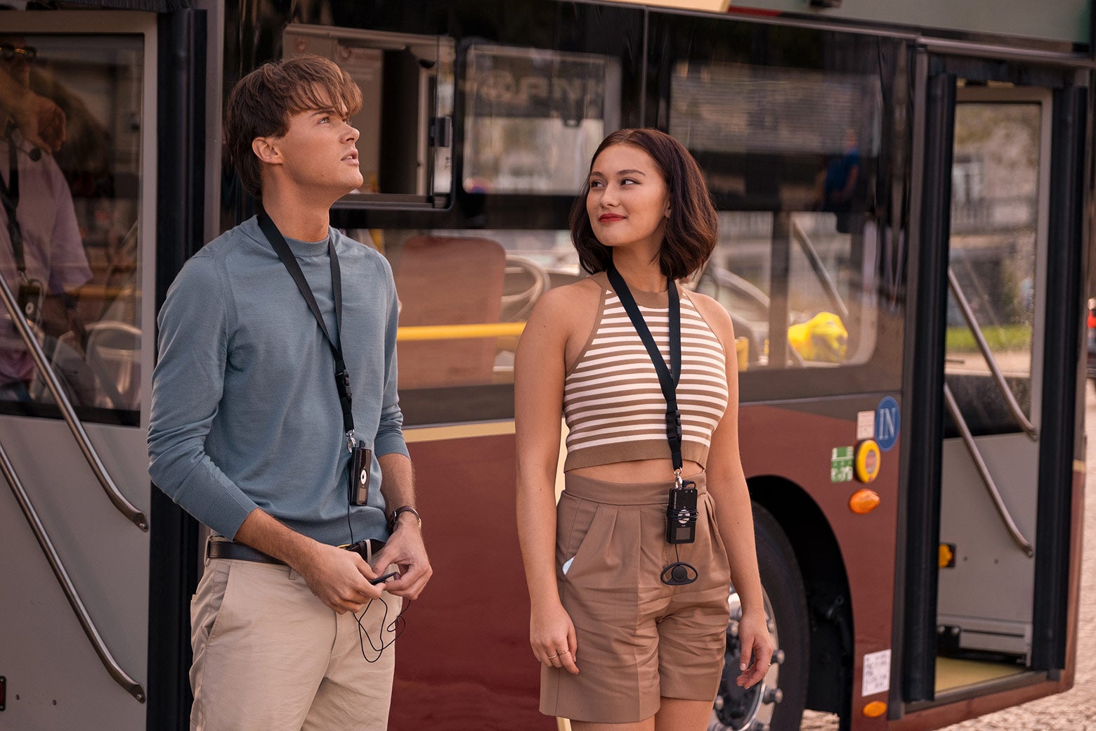 Conrad (Christopher Briney) and Belly (Lola Tung) standing in front of a bus in Paris.