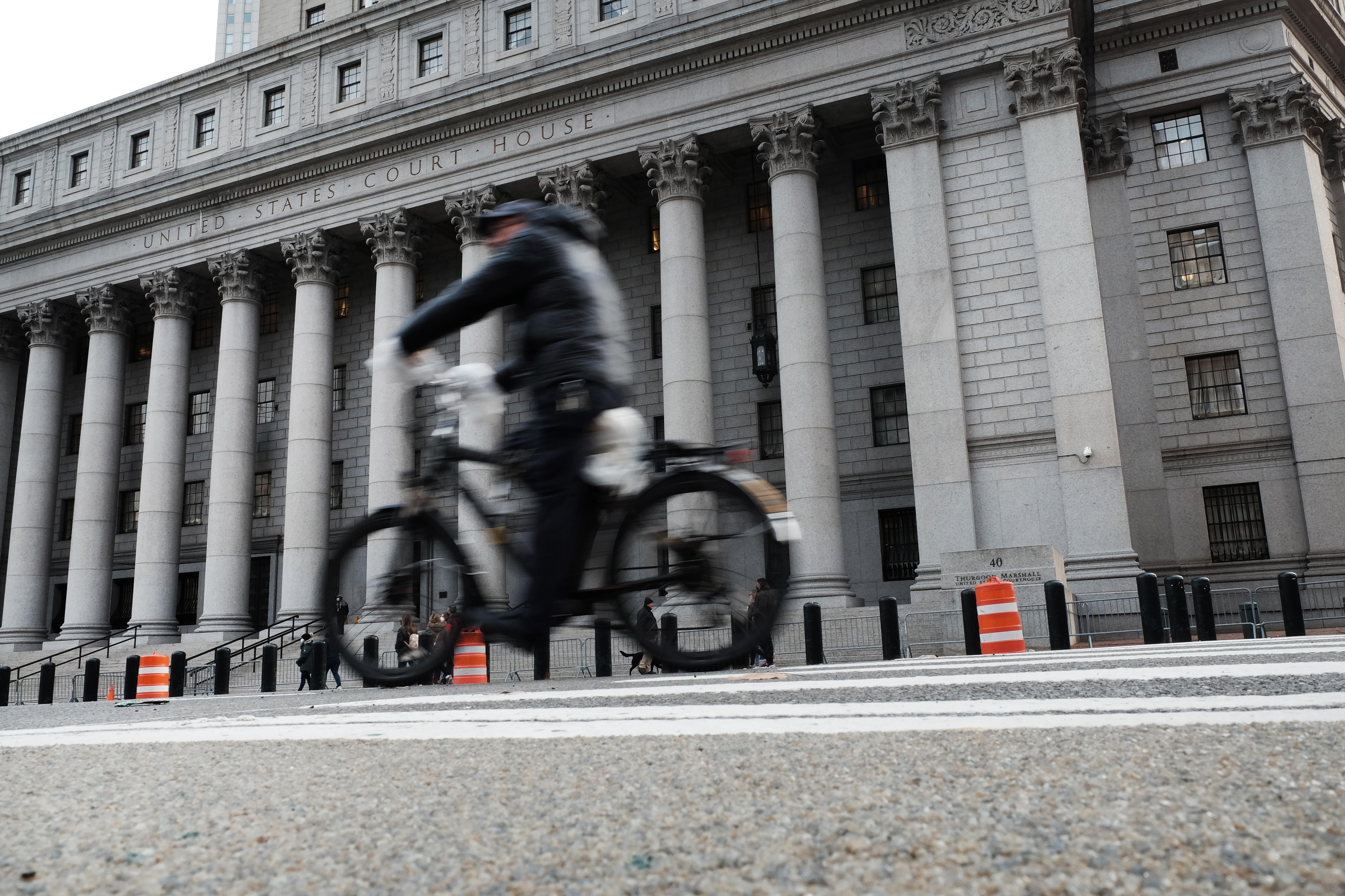 A cyclist passes in front of the courthouse