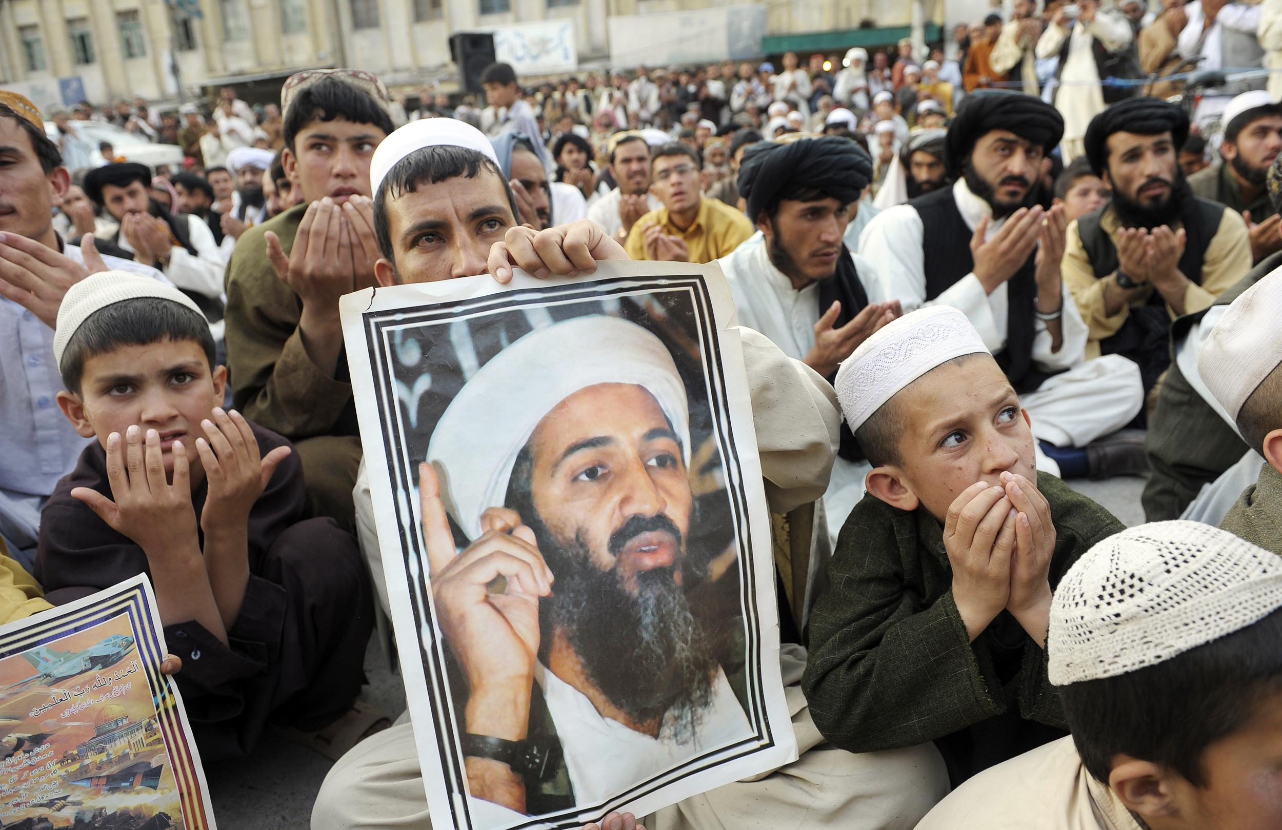 Supporters of hard-line pro-Taliban party Jamiat Ulema-i-Islam-Nazaryati (JUI-N) carry portraits of the slain al-Qaida leader Osama Bin Laden as they pray for Bin Laden during an anti-U.S. rally in Quetta on May 2, 2012.
