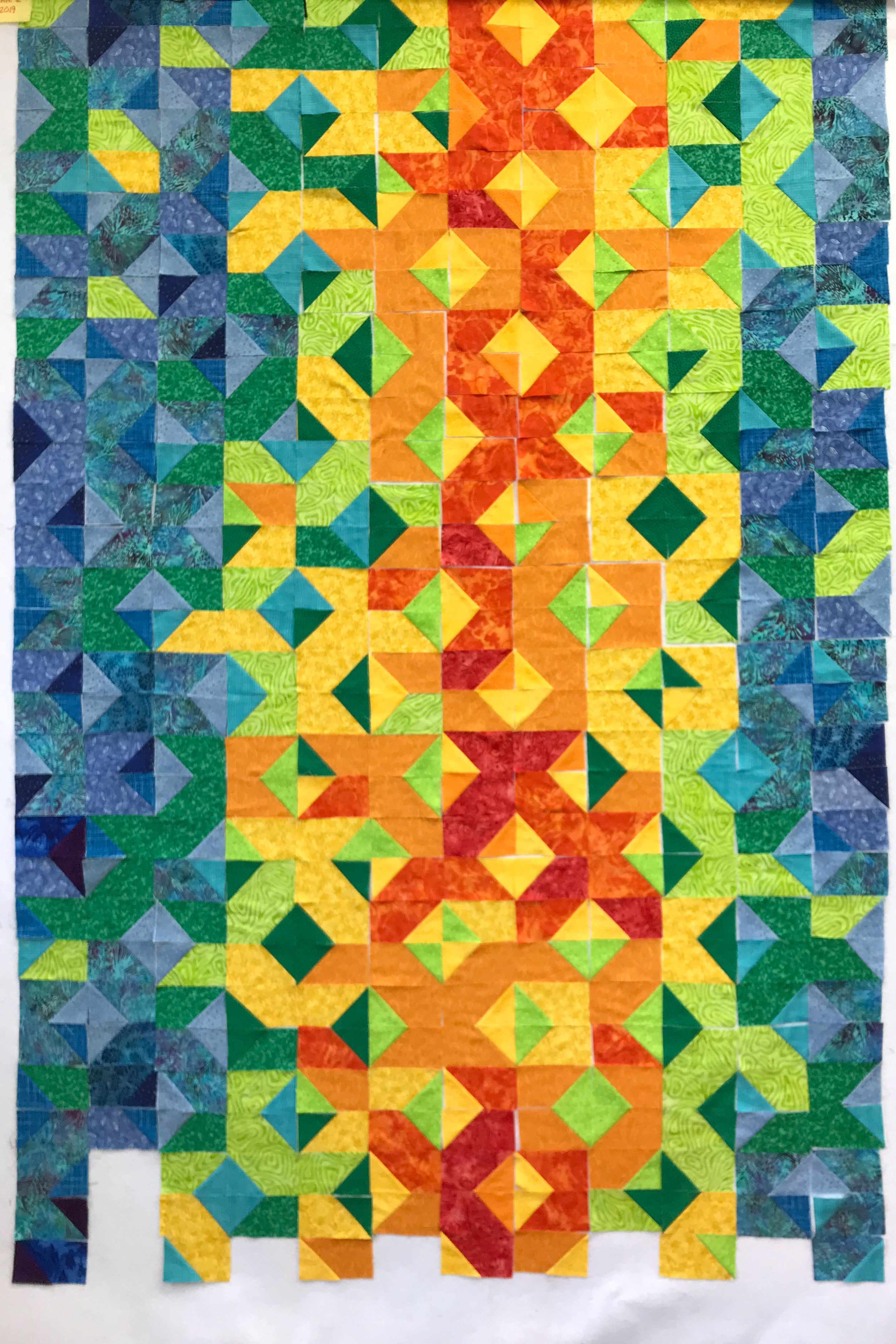 A quilt with reds, oranges, and yellows to represent hot temperatures and blues and greens to represent cool temperatures.