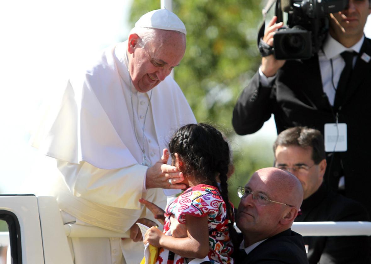 Pope Francis greets Sophie after she ran towards him during a pa