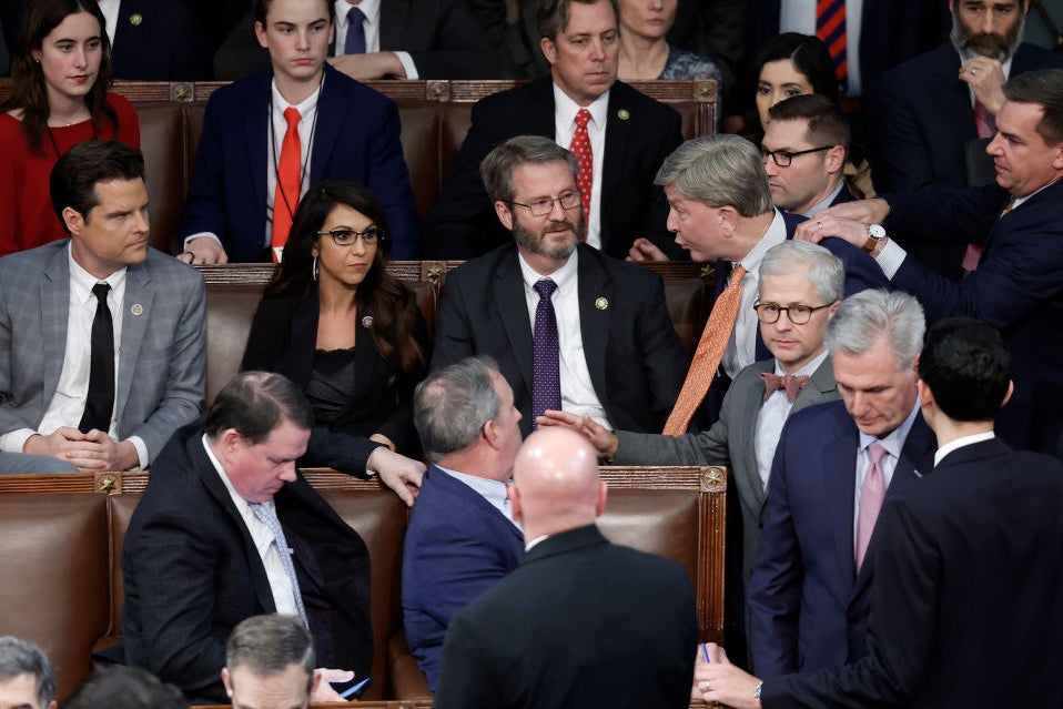 Rogers leans toward Gaetz, who is seated in the third seat from the aisle.