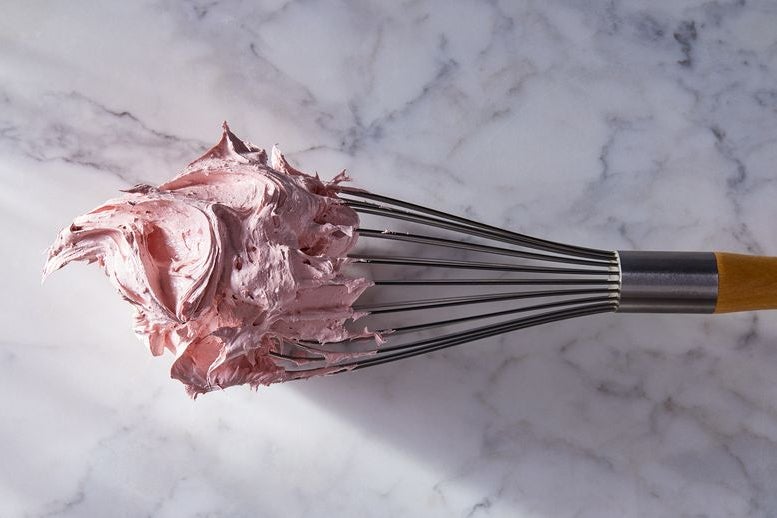 A glob of pink nougat sticks to a whisk.