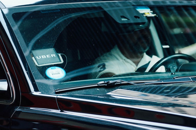 An Uber driver waits in an SUV for a client.
