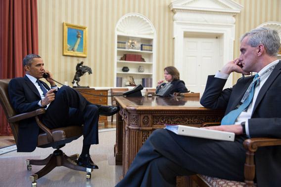 President Obama (L) talks on the phone and Chief of Staff Denis McDonough.