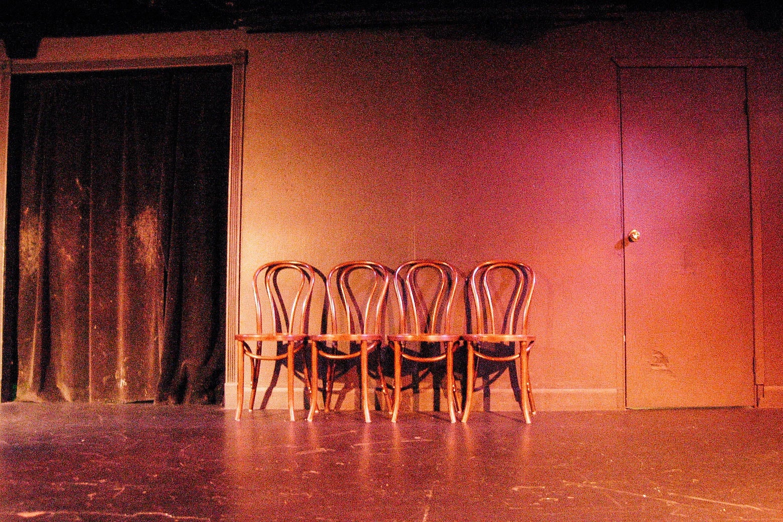 An empty stage with several chairs on it.