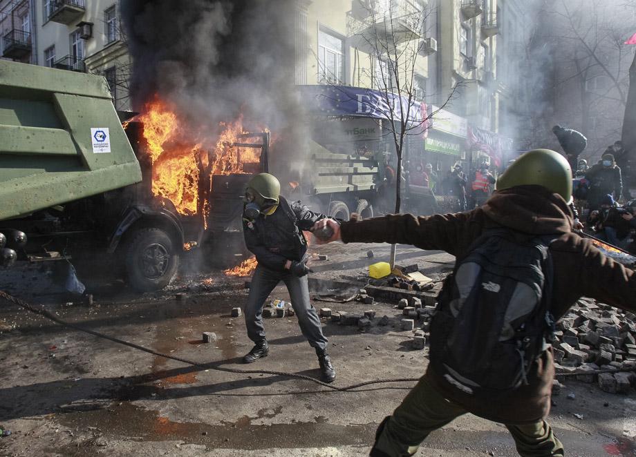 Anti-government protesters throw stones toward Interior Ministry officers during a rally near Vekhovnaya Rada, Ukraine's parliament, in Kiev on Feb. 18, 2014. 