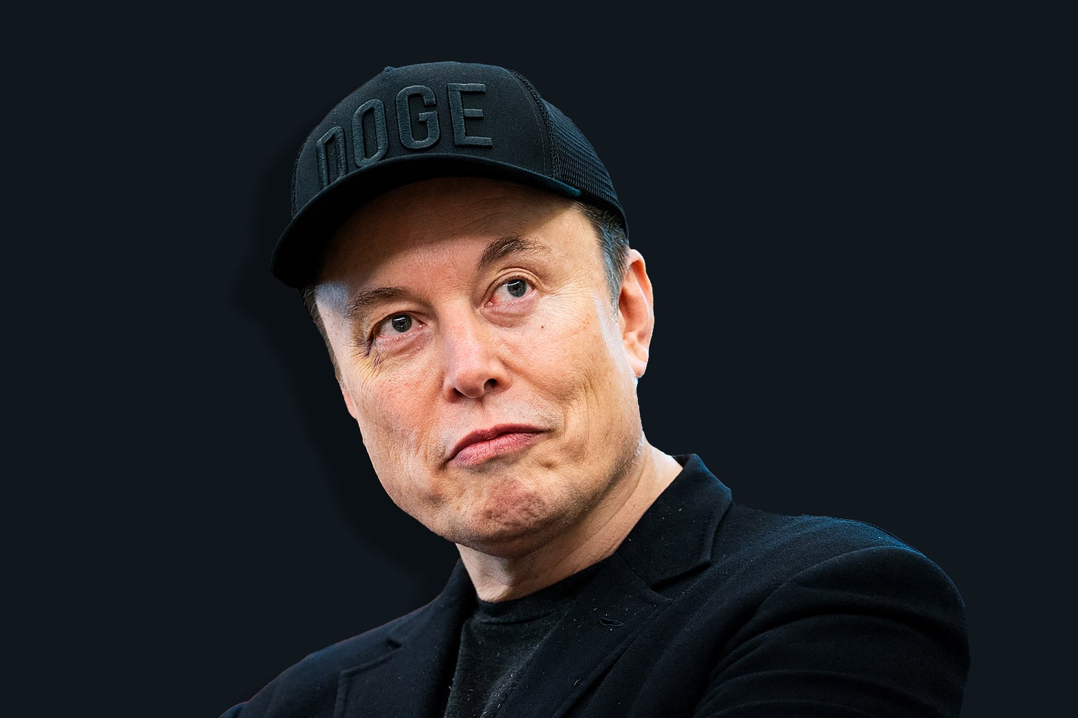 Elon Musk smirking and wearing all black and a black DOGE hat.