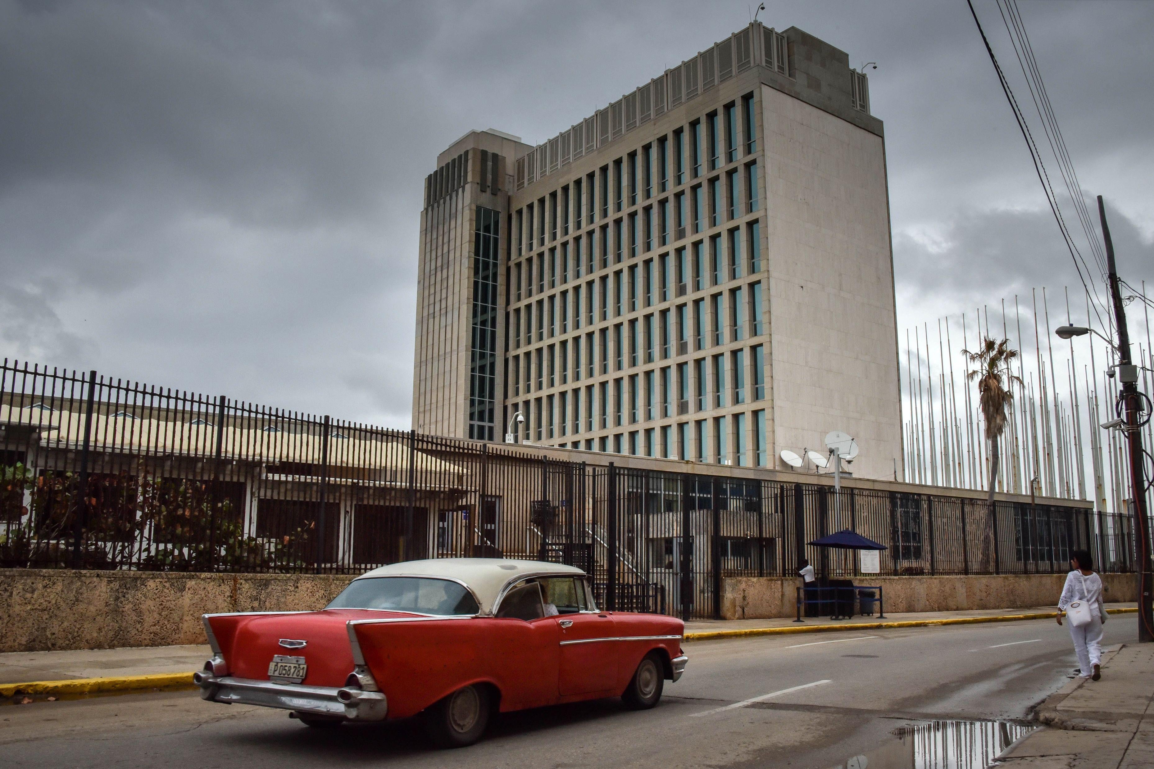 The U.S. embassy in Havana with a classic vintage car out front.