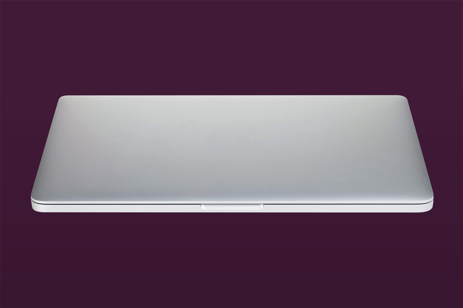 A shut laptop on a dark background.