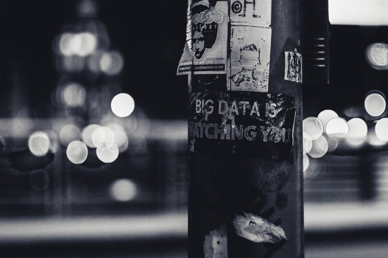 A pole with graffiti that says "Big Data Is Watching You."