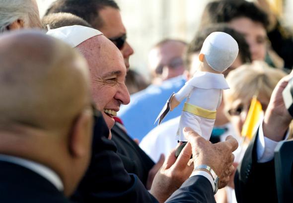 Pope Francis is given a gift as he greets well wishes after arri