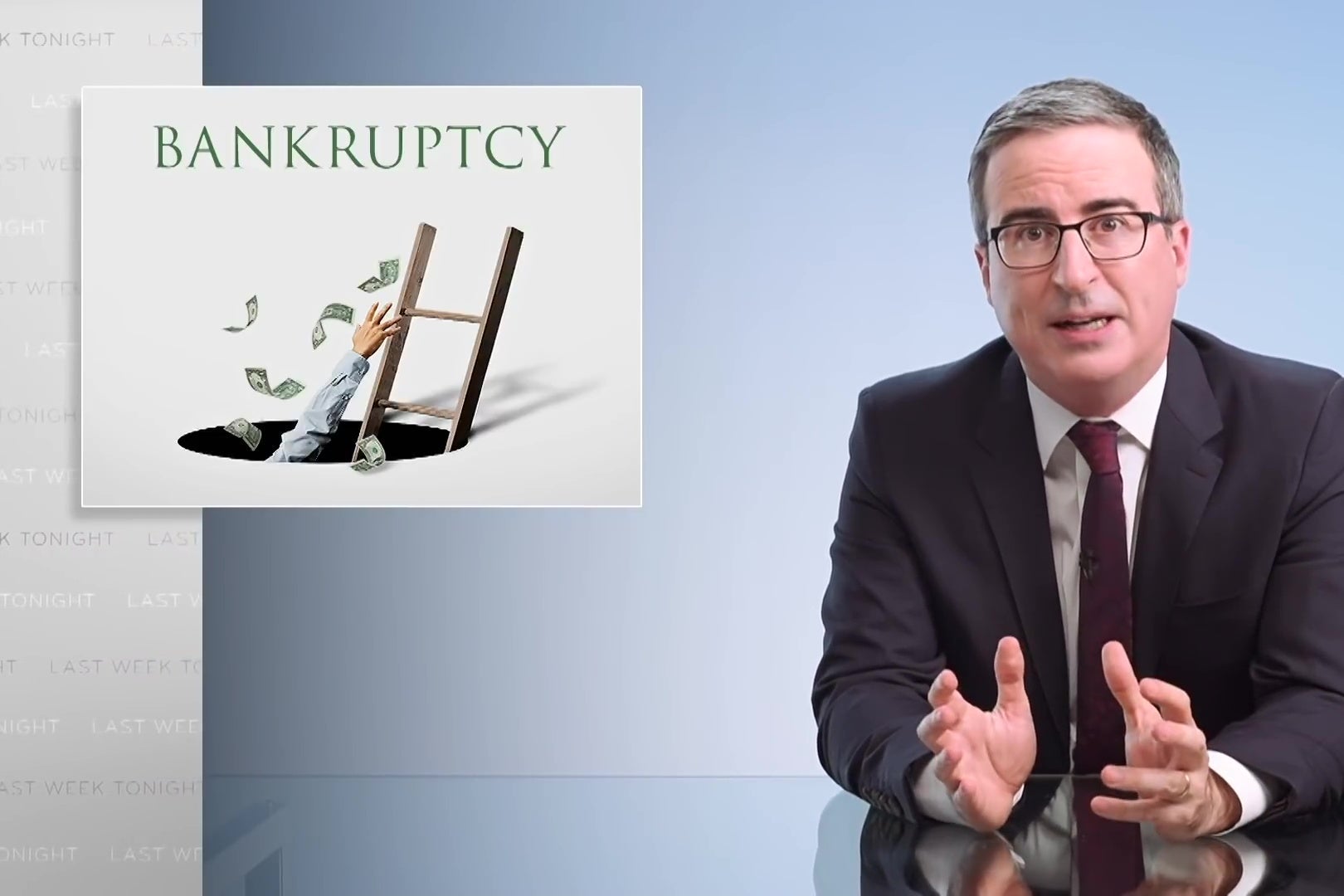 John Oliver sits at a glass desk in front of a sign reading bankruptcy.