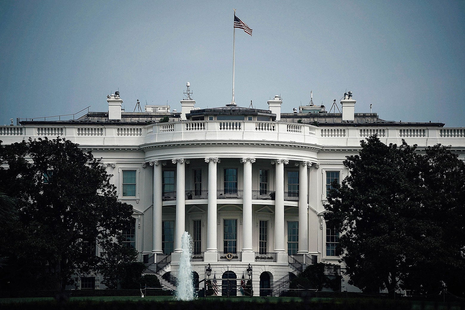 The White House with a flag on top, flown at full staff.