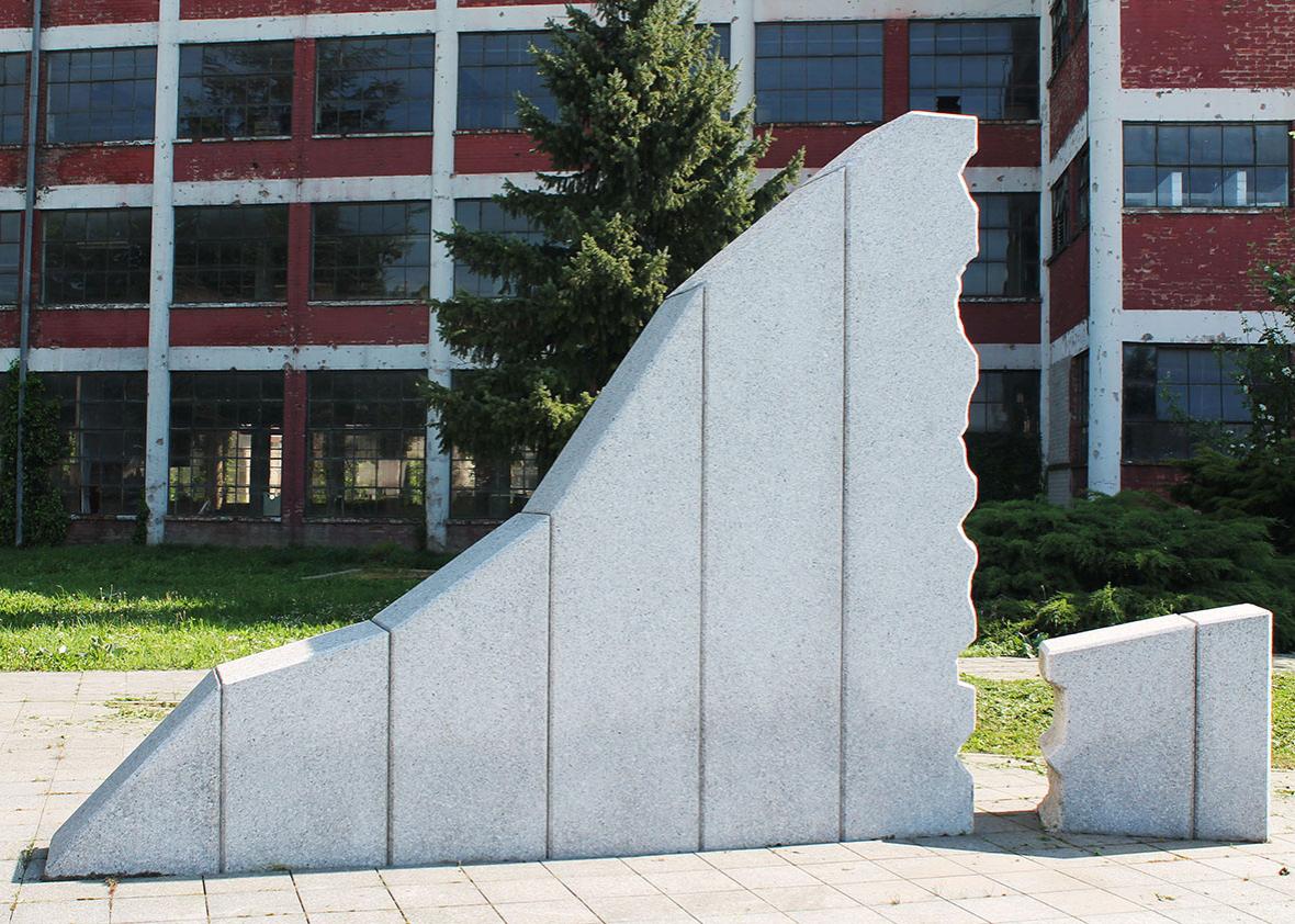 The sculpture carved in white stone represents the evolution of the factory. 