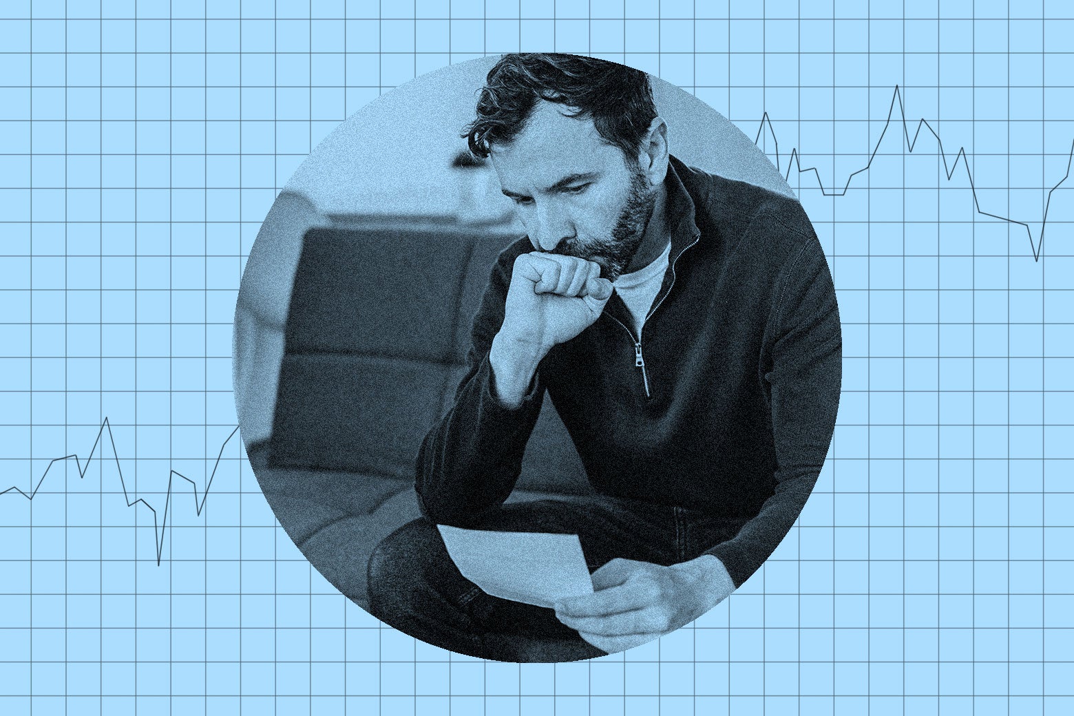 A man looking at a piece of mail. He looks stressed.