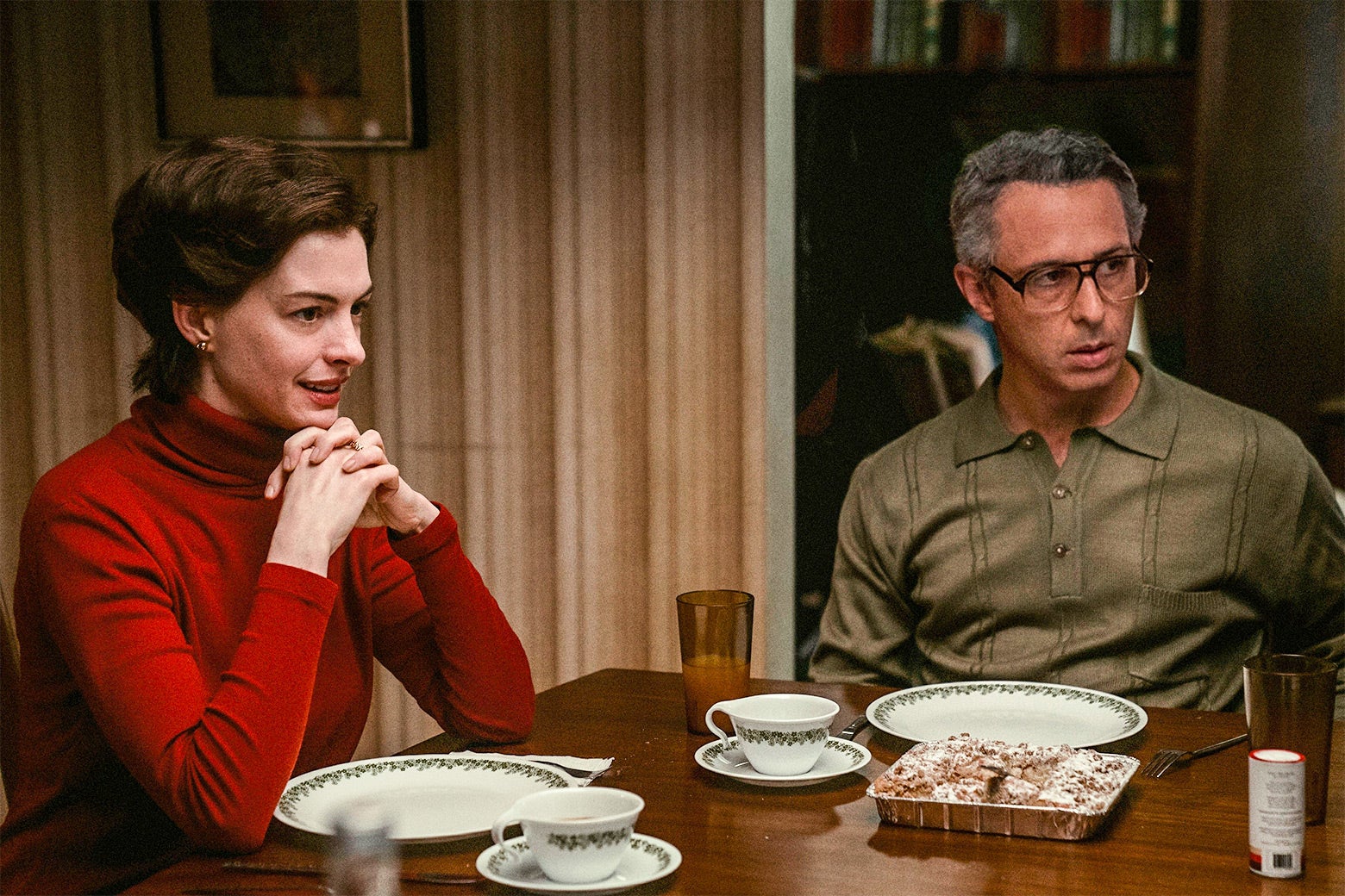 Anne Hathaway and Jeremy Strong sitting at a dinner table in a scene from Armageddon Time.