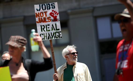 A protestor holds a sign during a demonstration against unemployment benefit cuts.