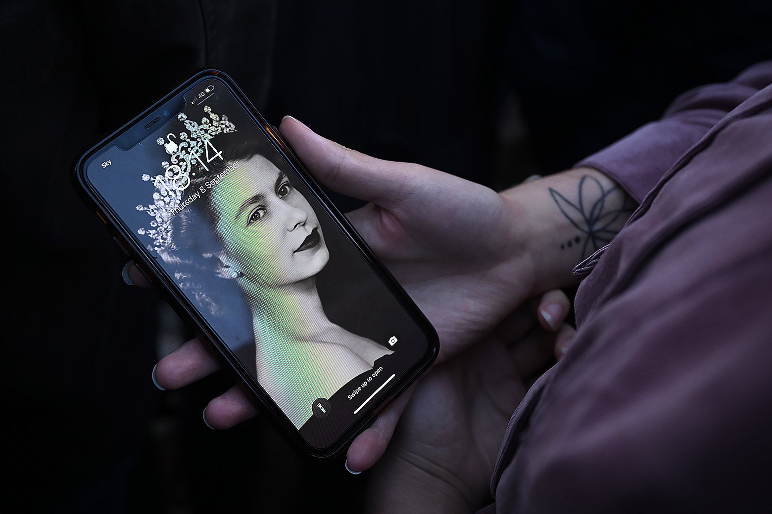 A person holds their phone with a screensaver of Queen Elizabeth II on Thursday in London. 