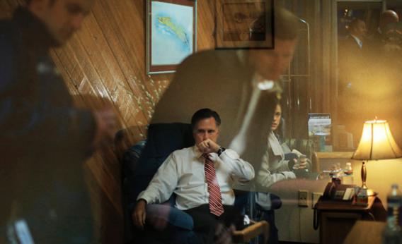 Staff members reflected off the window of the room where Republican presidential nominee Mitt Romney works before a campaign rally.
