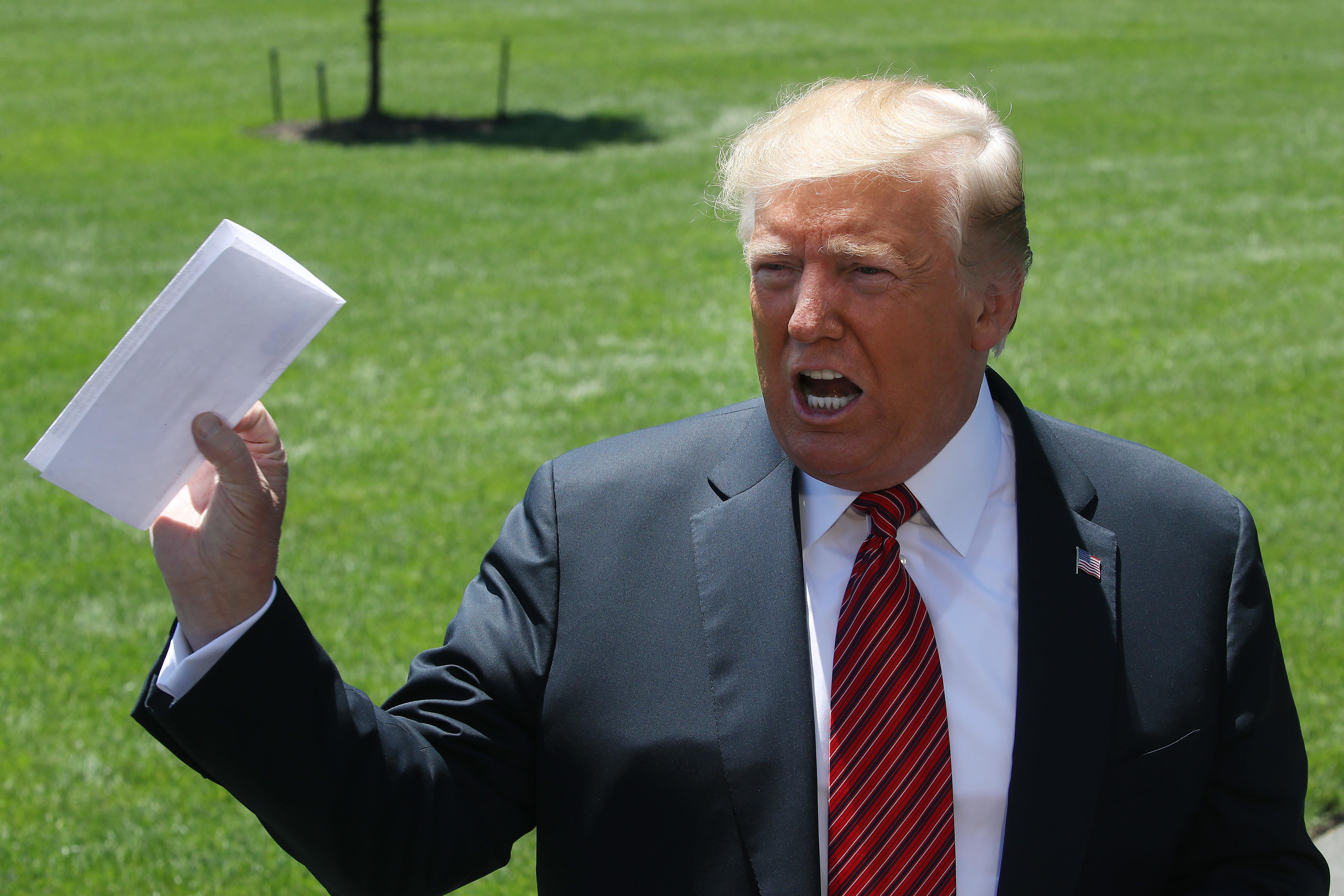 President Donald Trump holds a piece of paper he said was a trade agreement with Mexico, while speaking to the media before departing from the White House on June 11, 2019 in Washington, D.C.