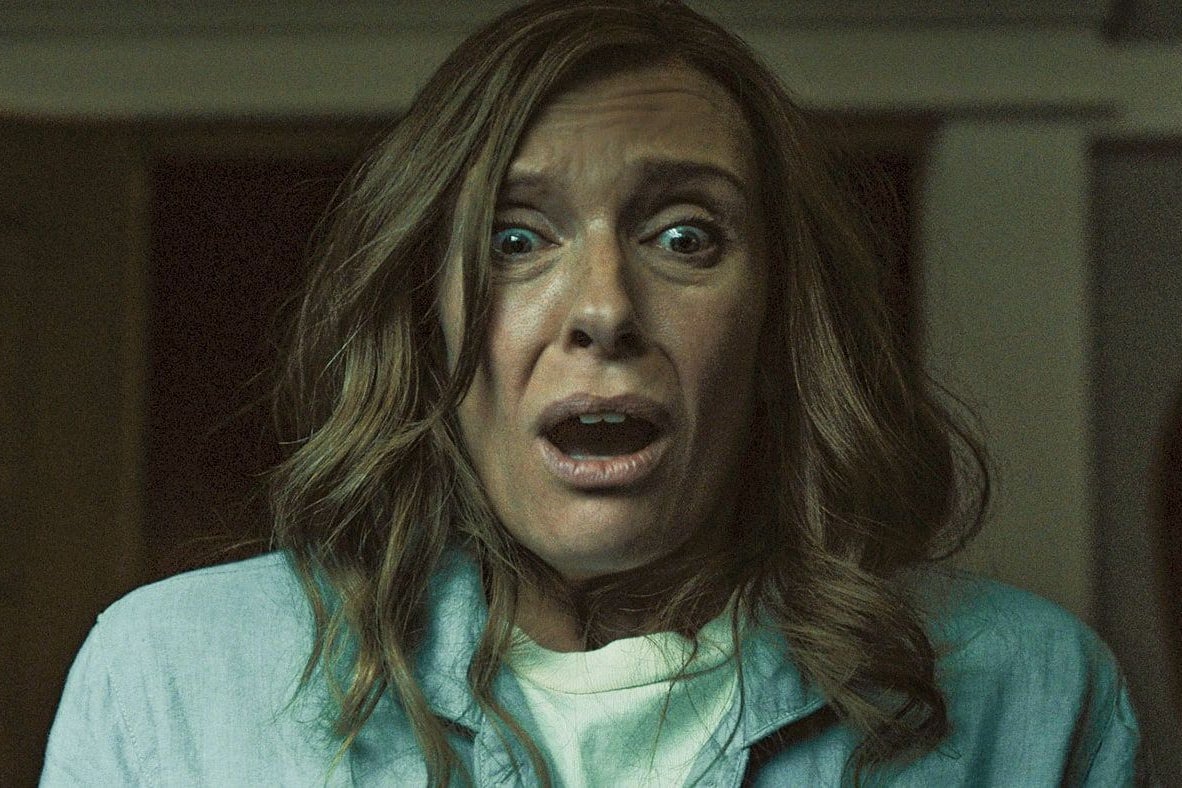 Toni Collette stares ahead with her mouth agape and eyes wide with horror. 