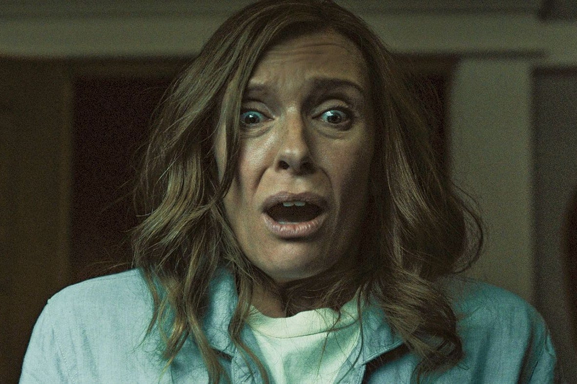 Toni Collette stares ahead with her mouth agape and eyes wide with horror.