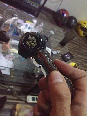 Rob holds his glass bowl, filled with marijuana