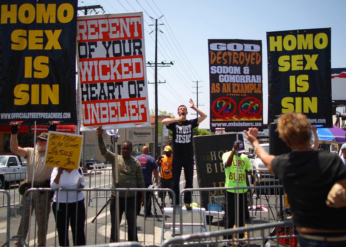 Anti-gay Christian protesters preach and hold banners at the LA Pride Parade on June 8, 2014 in West Hollywood, California. 