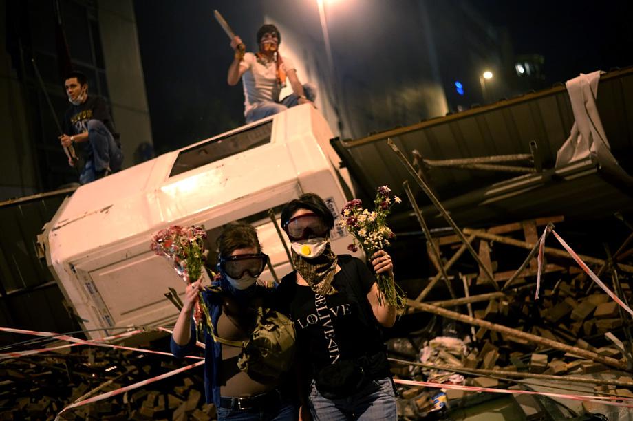 Demonstrators hold flowers between Taksim and Besiktas in Istanbul on June 4, 2013 during a demonstration against the demolition of the park.
