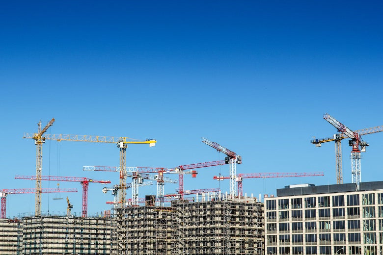 Cranes over buildings being built.