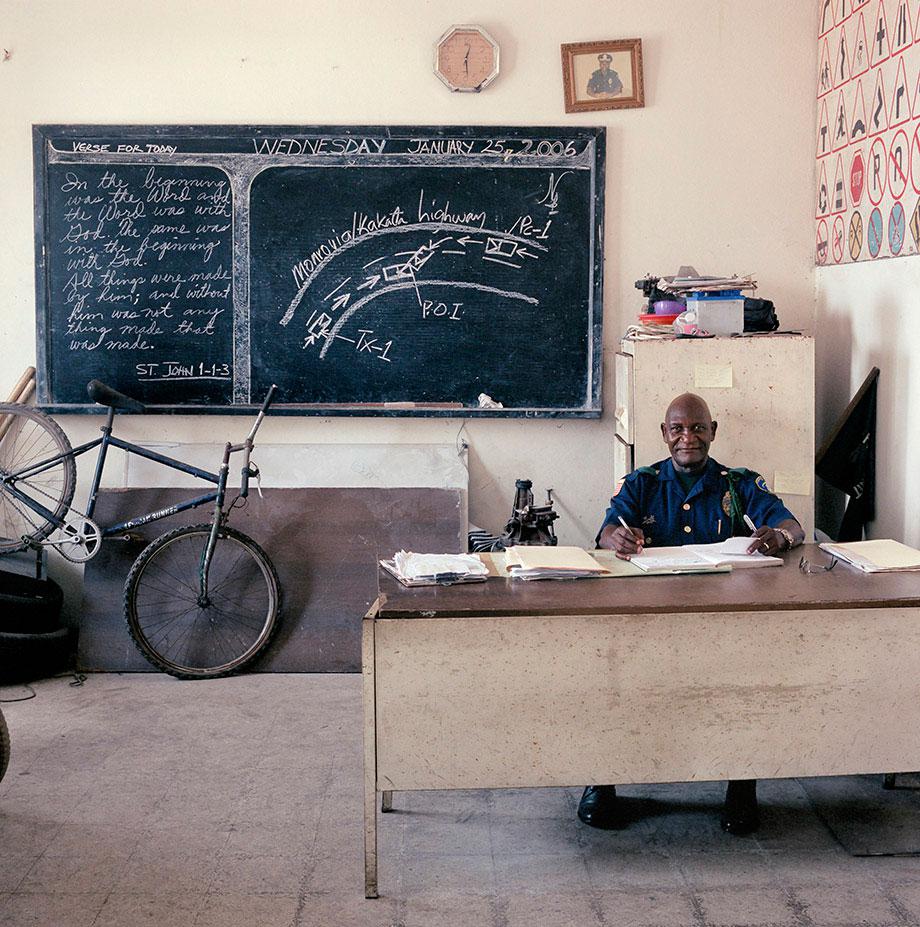 Liberia, bureaucracy, (c) Jan Banning 2006.Liberia-04/2006 [Mon., AD (b. 1940)]Major Adolph Dalaney (b. 1940) works in the Reconstruction Room of the Traffic Police at the Liberia National Police Headquarters in the capital Monrovia. Monthly salary: barely 1,000 Liberian dollars ($ 18, euro 17). Traffic accident victims at times are willing to pay a little extra if Dalaney"s department quickly draws up a favorable report to present to a judge.Liberia-04/2006 [Mon., AD (b. 1940)]Major Adolph Dalaney (1940) werkt in de Reconstruction Room of the Traffic Police at the Liberia National Police Headquarters in de hoofdstad Monrovia. Maandsalaris: krap 1000 Liberiaanse dollar (17 euro, 18 $). Gedupeerden bij een verkeersongeluk willen wel eens wat extra"s betalen als de afdeling van Dalaney snel in hun voordeel een rapport opmaakt voor de rechter.