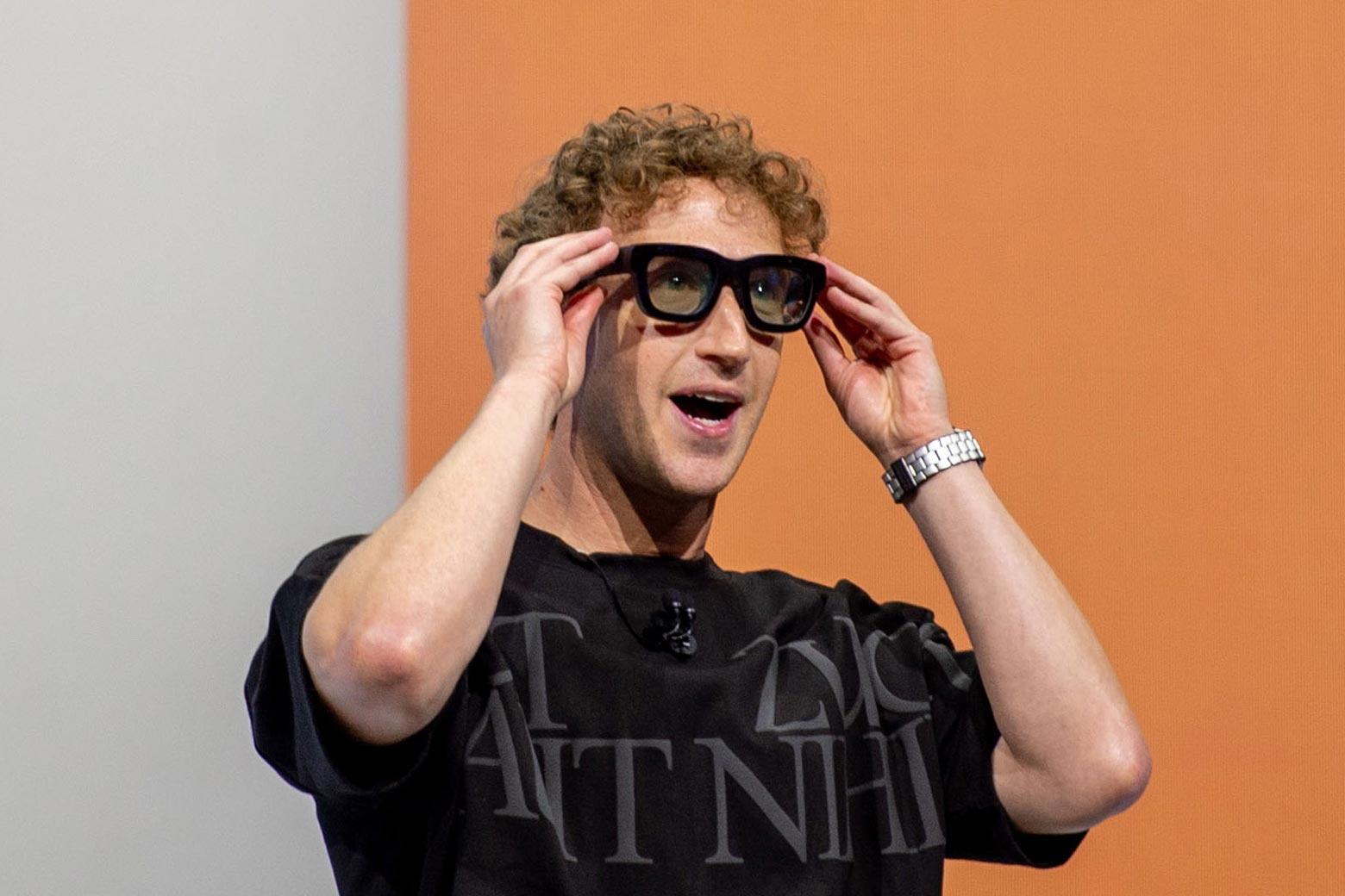 Meta CEO Mark Zuckerberg demonstrates his company's Orion smart glasses, which are quite large and black, and tinted.