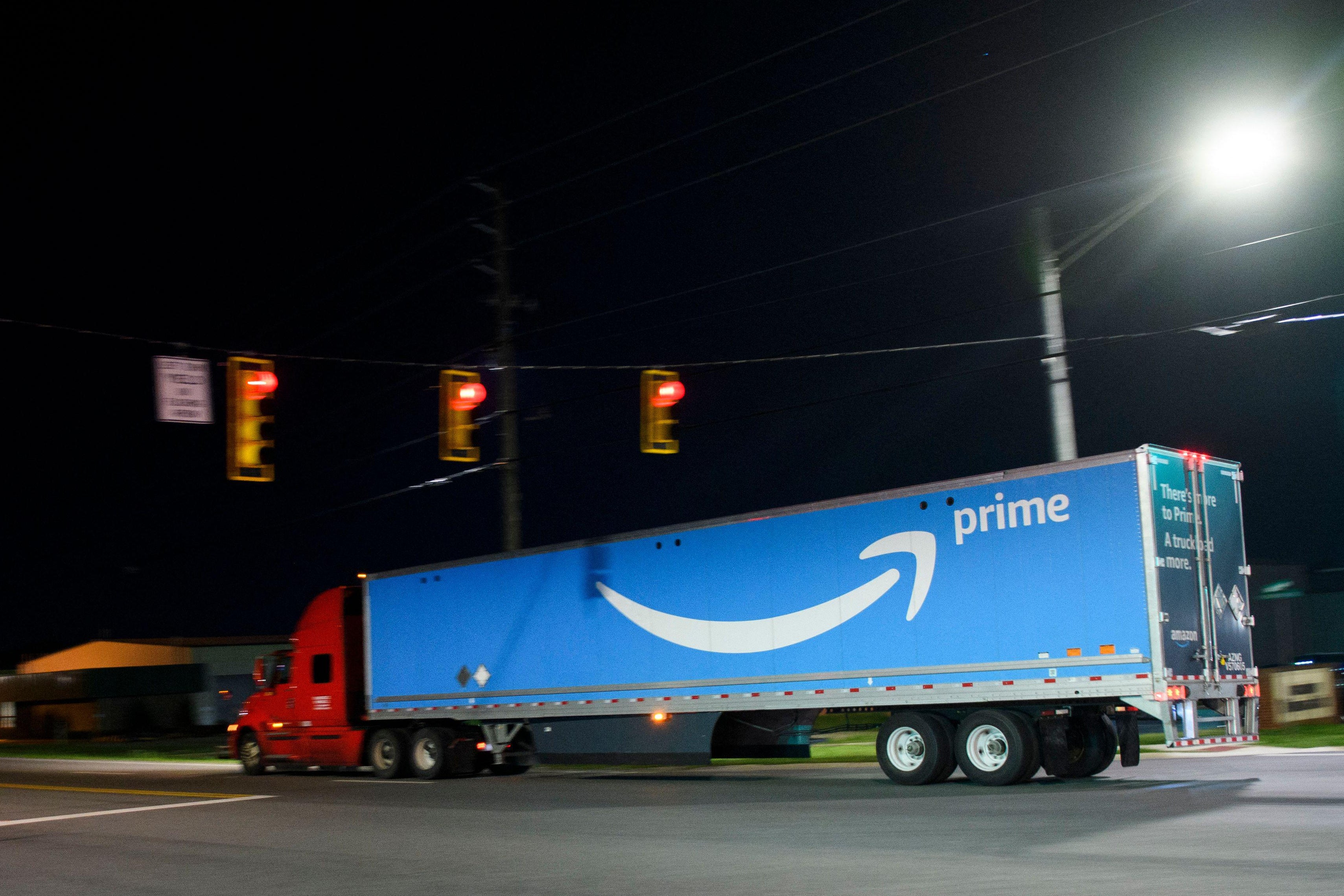 A truck carries a trailer with the Amazon Prime logo past the Amazon.com, Inc. BHM1 fulfullment center on March 29, 2021 in Bessemer, Alabama. 