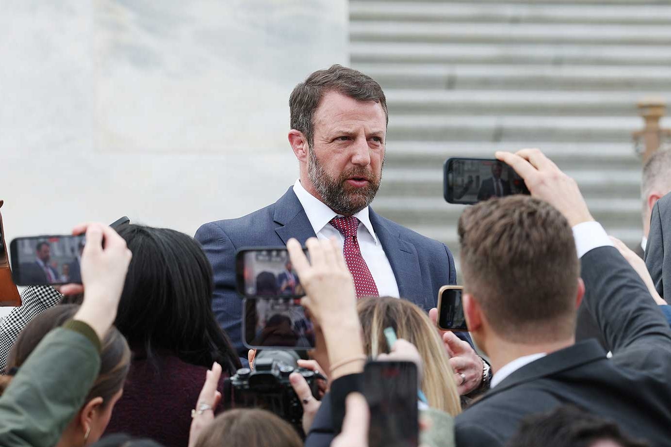 Markwayne Mullin surrounded by reporters.