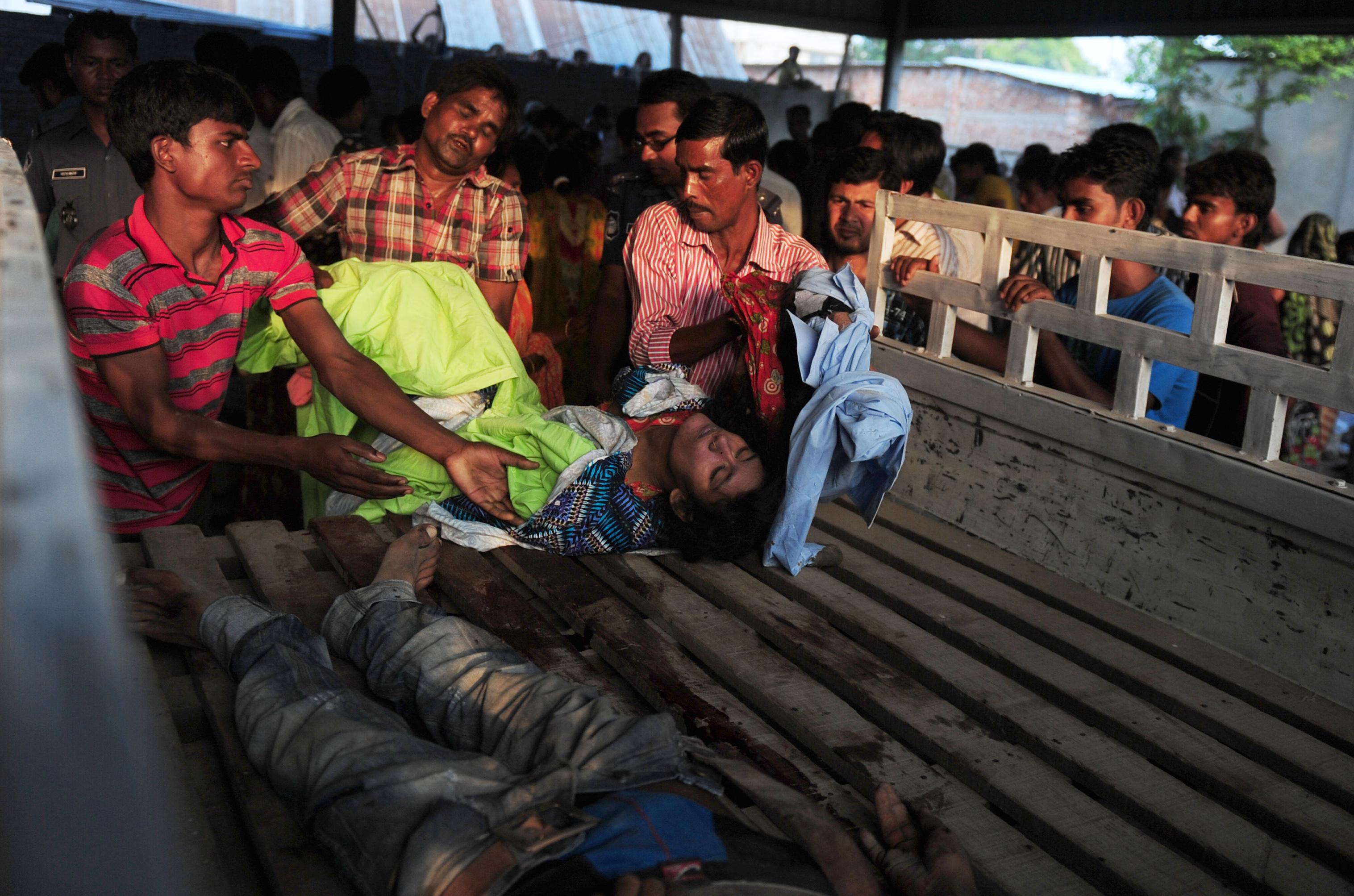 Bangladeshi volunteers and workers load dead bodies onto a truck at the site of a building collapse in Savar, on the outskirts of Dhaka, on April 24, 2013.
