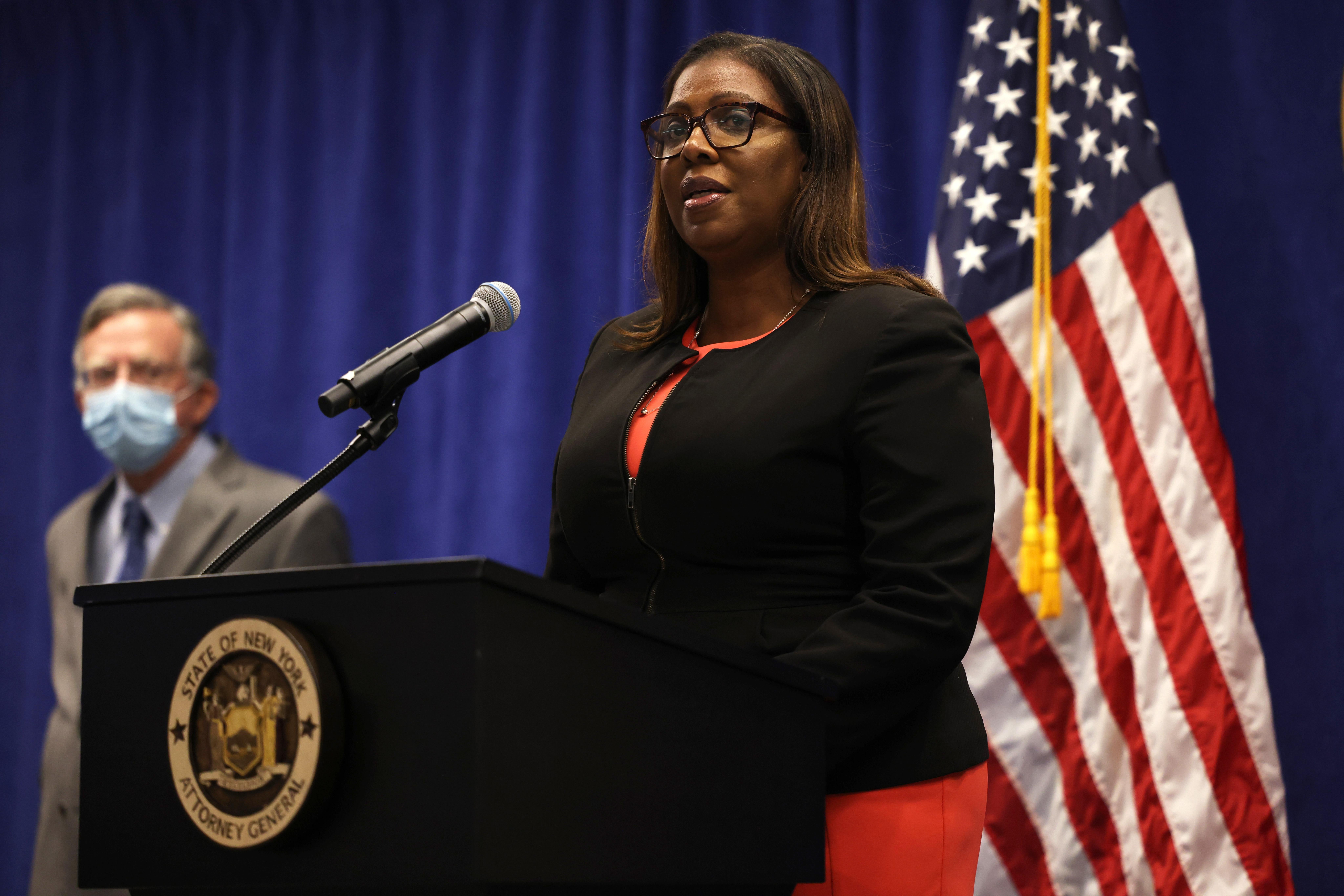 Letitia James stands at a podium with an American flag backdrop.