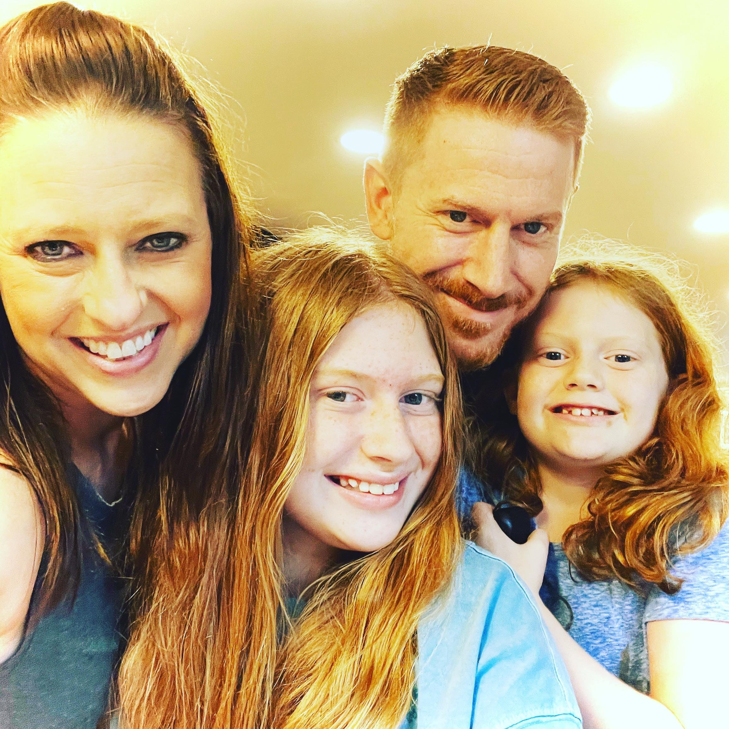 A family selfie with a woman, a man, and two girls.