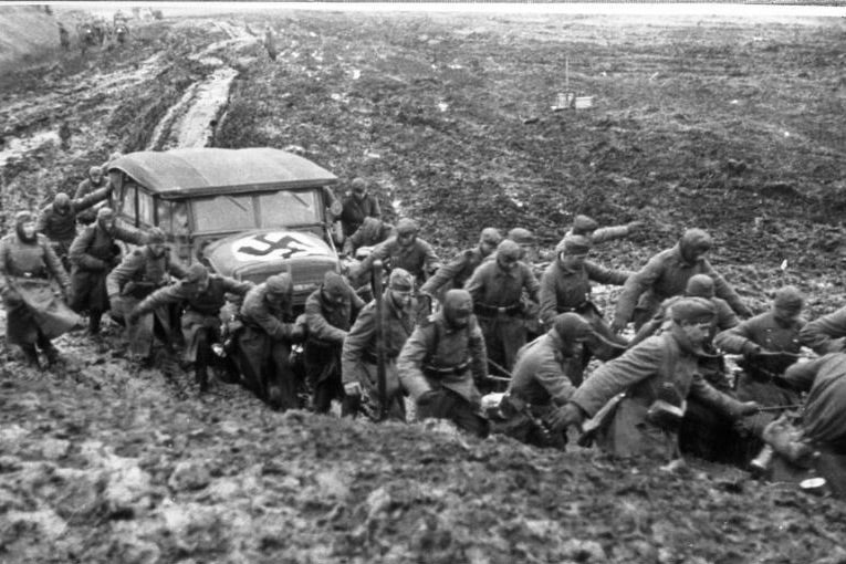 Soldiers pull an auto out of the mud. 