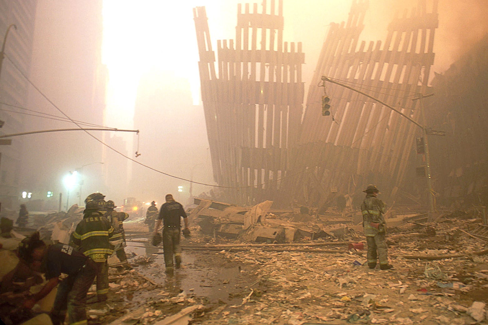 Rescue crews engulfed in a fog of dust set in the World Trade Center rubble