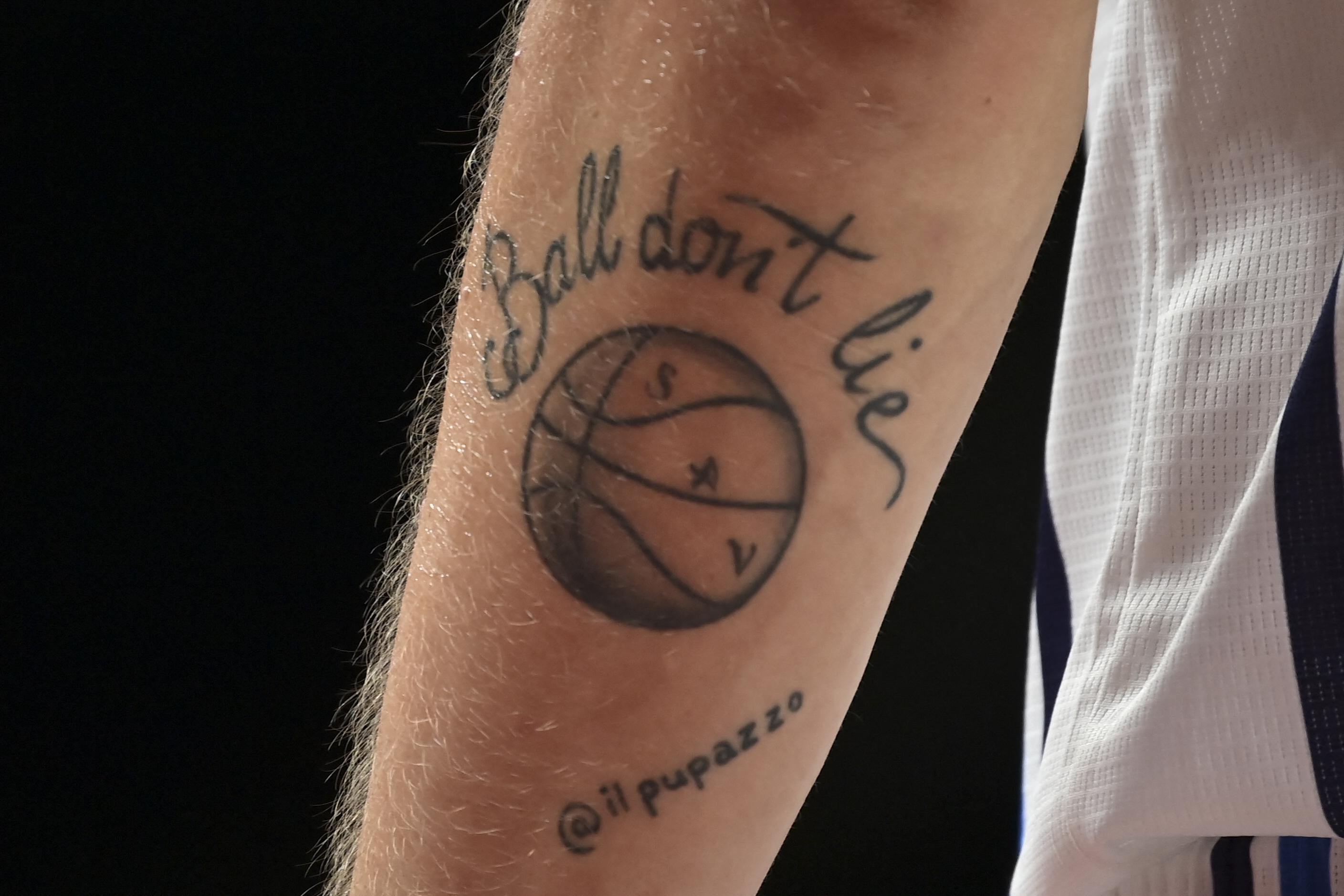 A tattoo reading "Ball don't lie" over a basketball with @ilpuppuzzo scrawled underneath it