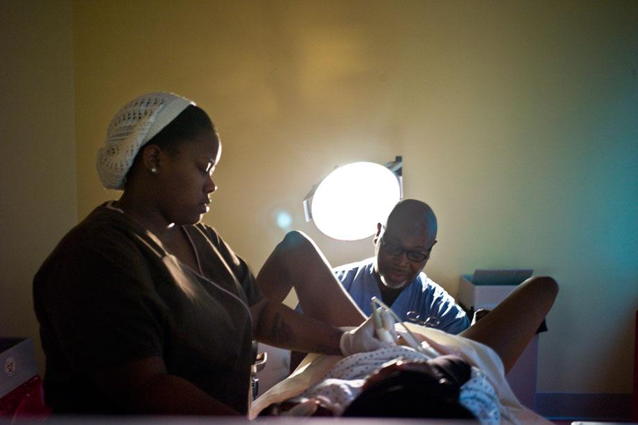 Dr. Willie Parker performs an abortion in November 2012 while Stephanie Battle assists. Parker is one of two physicians who fly to Mississippi to work at the clinic. It has had difficulty finding local providers. 