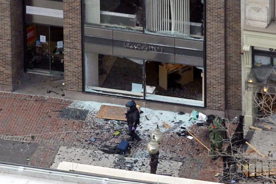 A man in a bomb-disposal suit investigates the site of an explosion that occurred on Boylston Street during the 117th Boston Marathon, April 15, 2013.