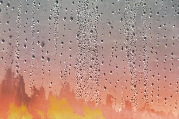 Fire as seen through a window covered in humidity-based condensation