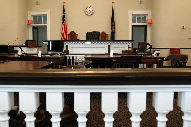 A view from the gallery in the back of a courtroom of the judge's chair and the witness stand.
