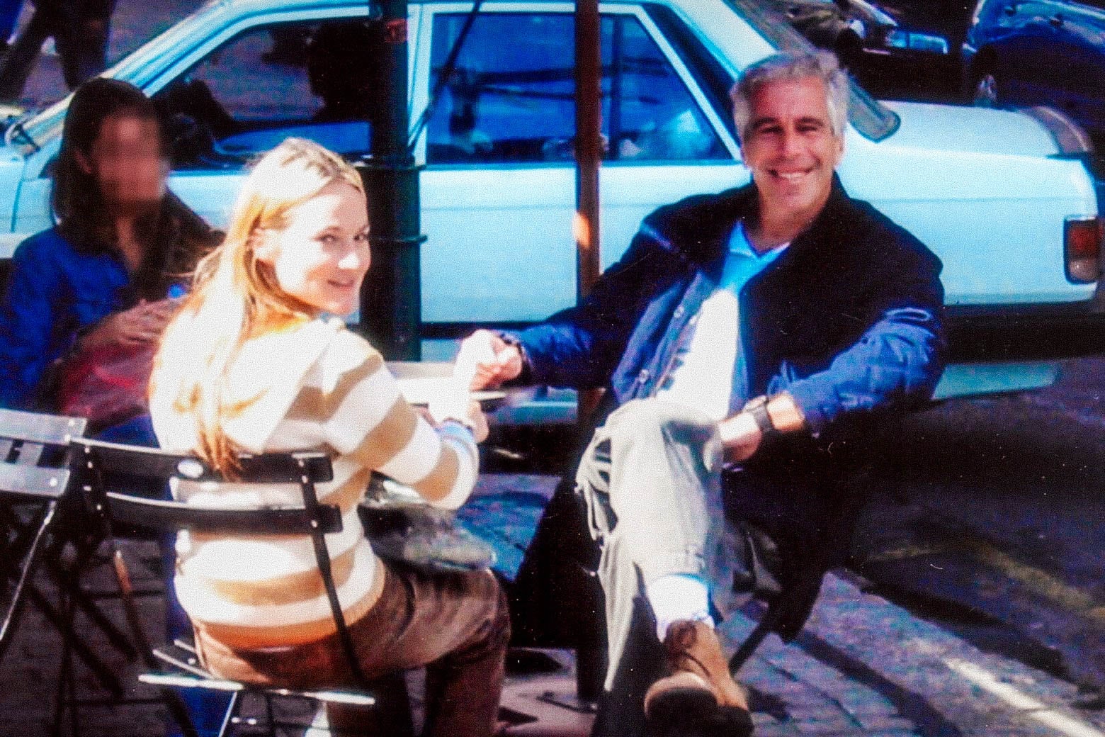Jeffrey Epstein, smiling, seated with Chauntae Davies at an outdoor bistro table.