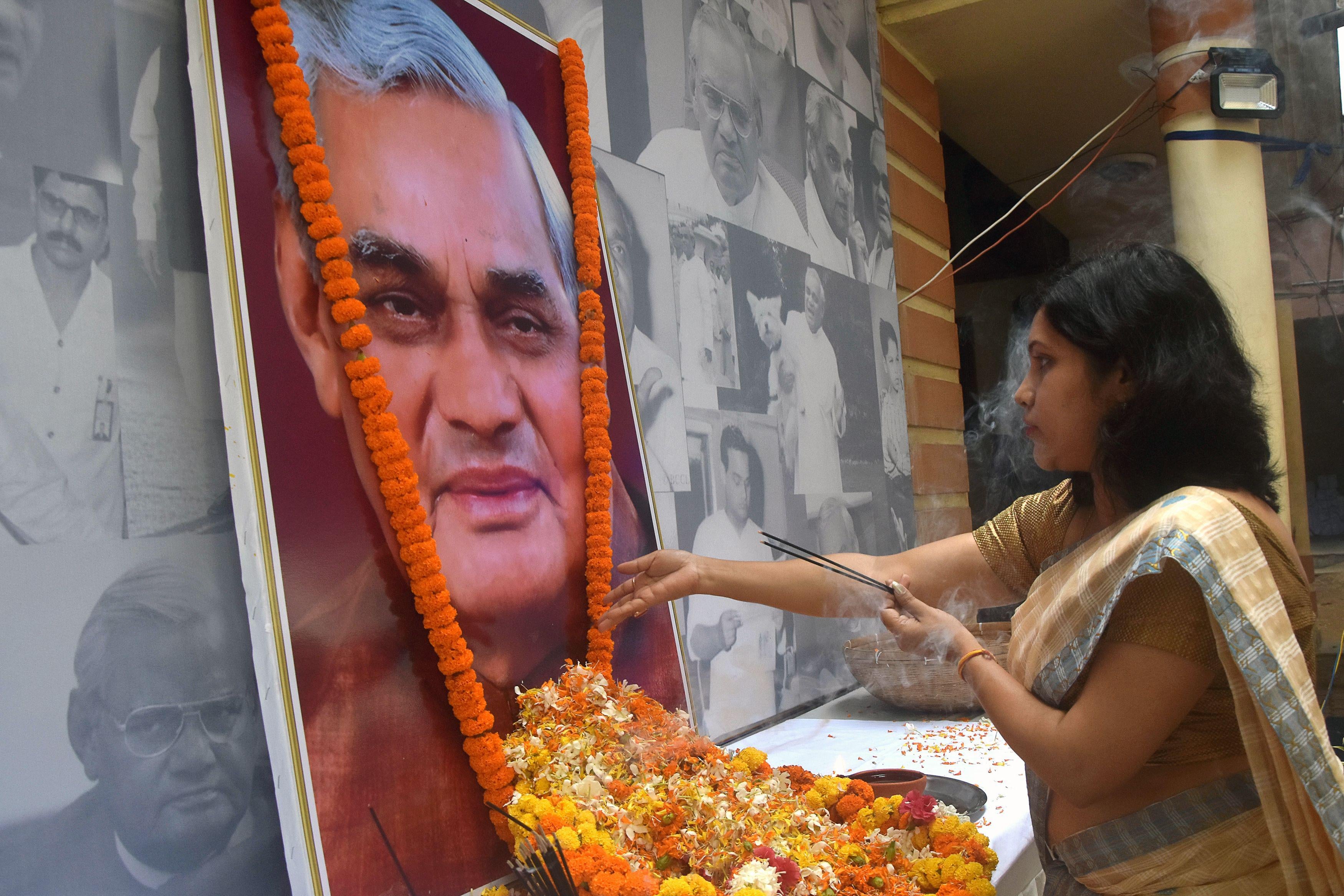 An Indian Bharatiya Janata Party worker pays tribute at a portrait of former Indian Prime Minister Atal Bihari Vajpayee in the state of Guwahati on Friday.