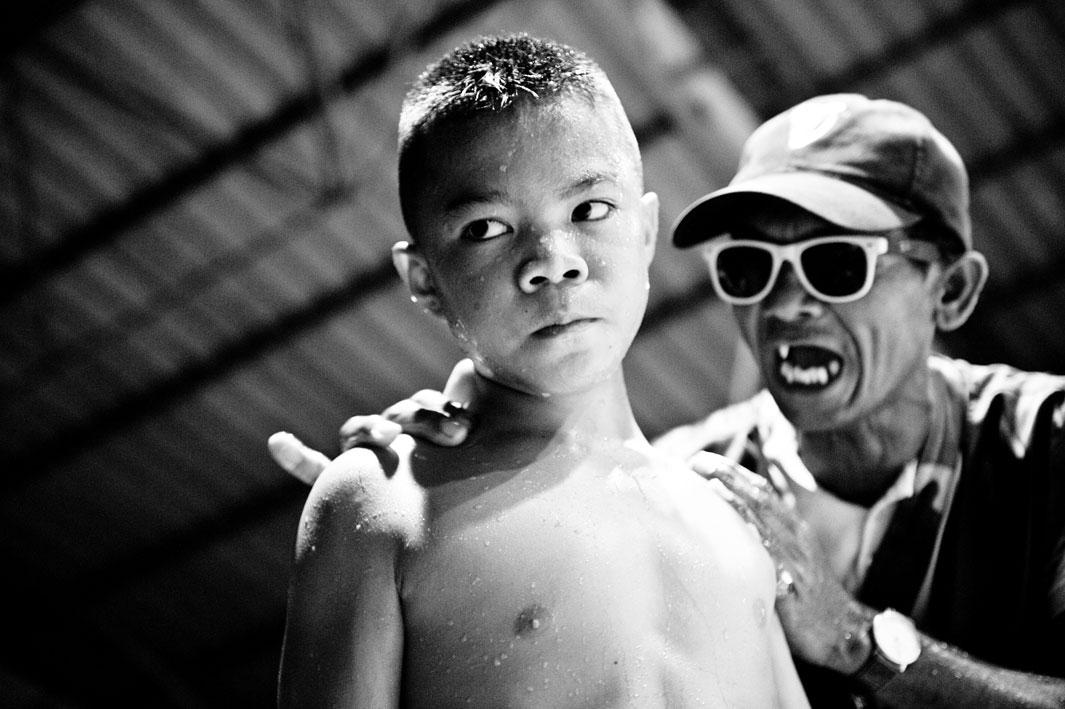 The coach shouts at a boy during the break of the fight.Muay Thai (Thai Boxing) is one of the toughest martial arts in the world. A minimum age for the fighters does not exist. For many poor people it secures their livelihood. For a pittance, they reach their mental and physical limits two or three times a month with boxing matches.