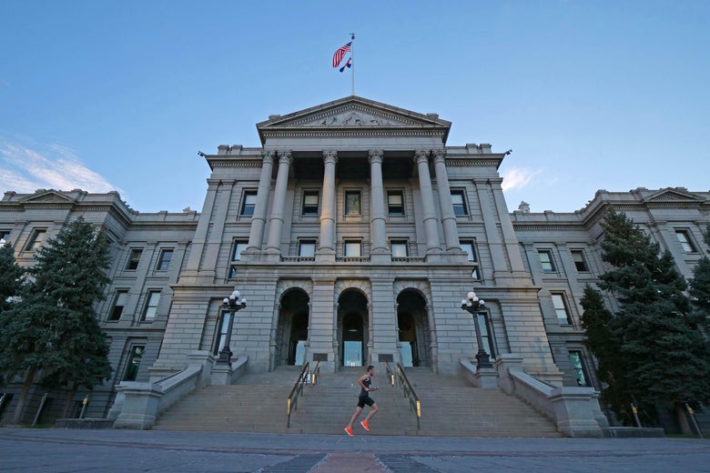 A runner is seen in front of the Colorado Capitol.