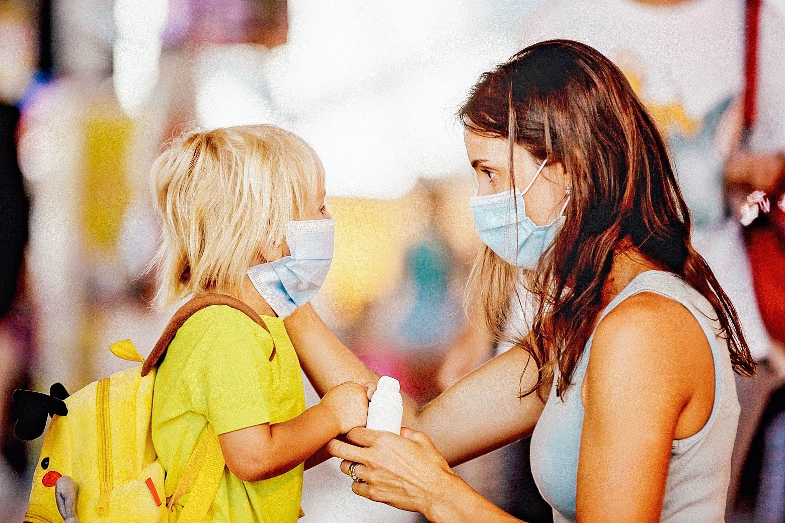 Mom face to face with her child, both wearing surgical masks
